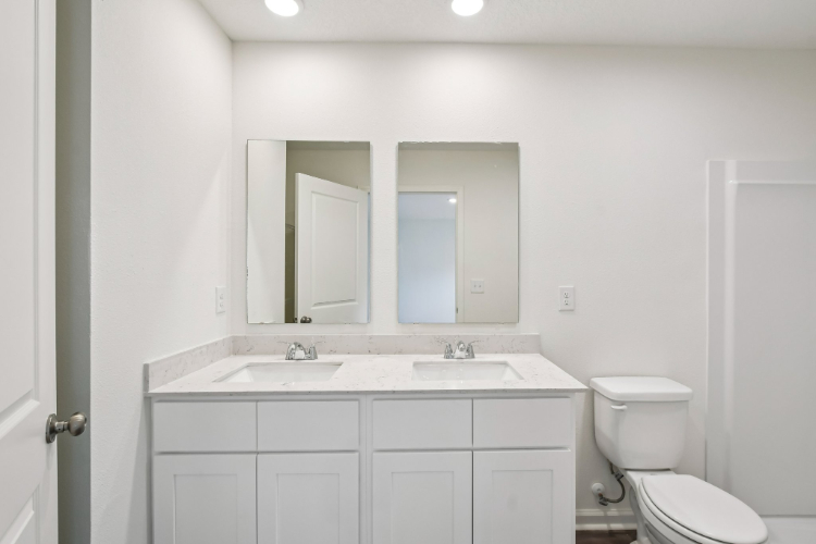 A bathroom with white cabinets.