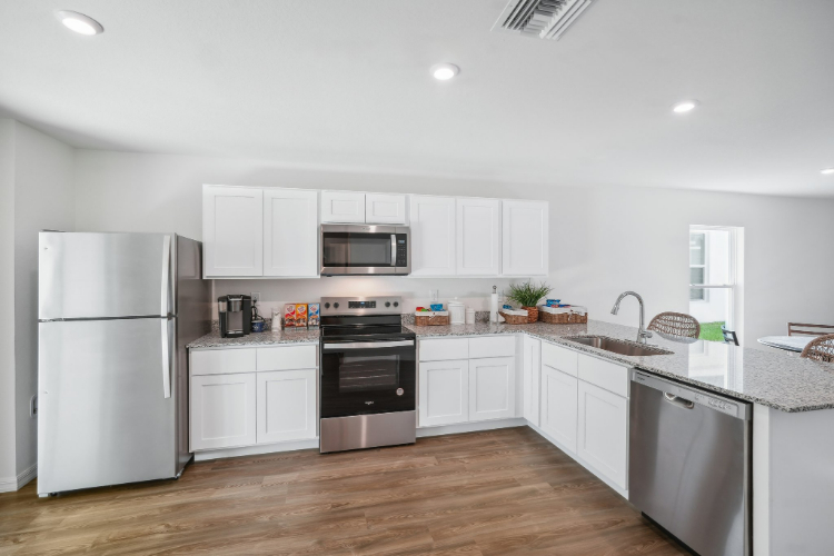 A kitchen with white cabinets.