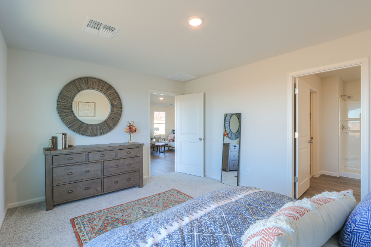 A bedroom with a large mirror.