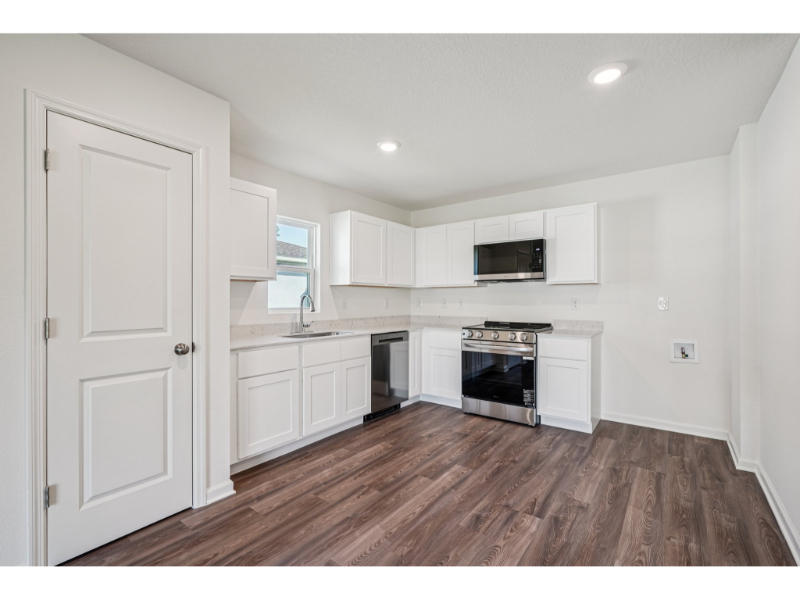 A kitchen with white cabinets.