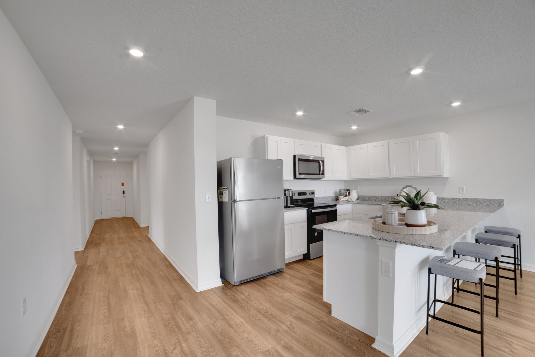 A kitchen with white cabinets.