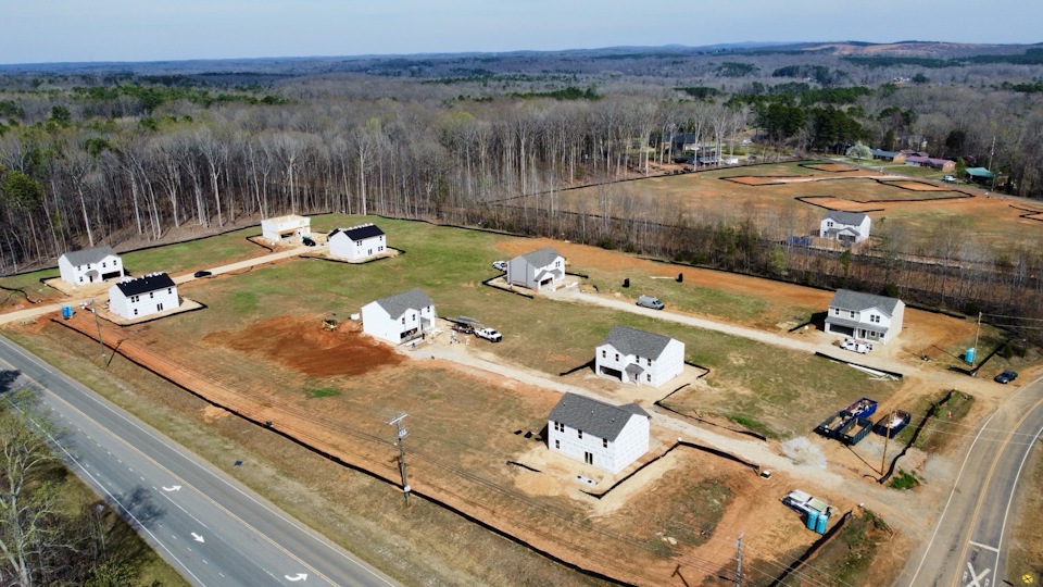 A group of white buildings in a field.
