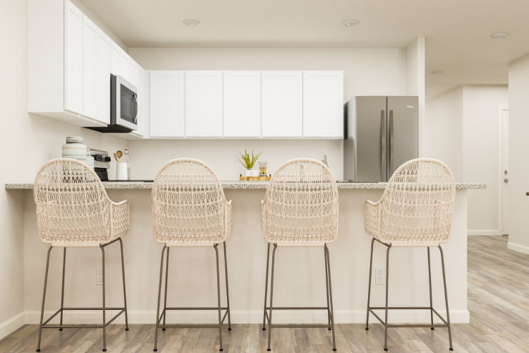 A kitchen with a bar stools.