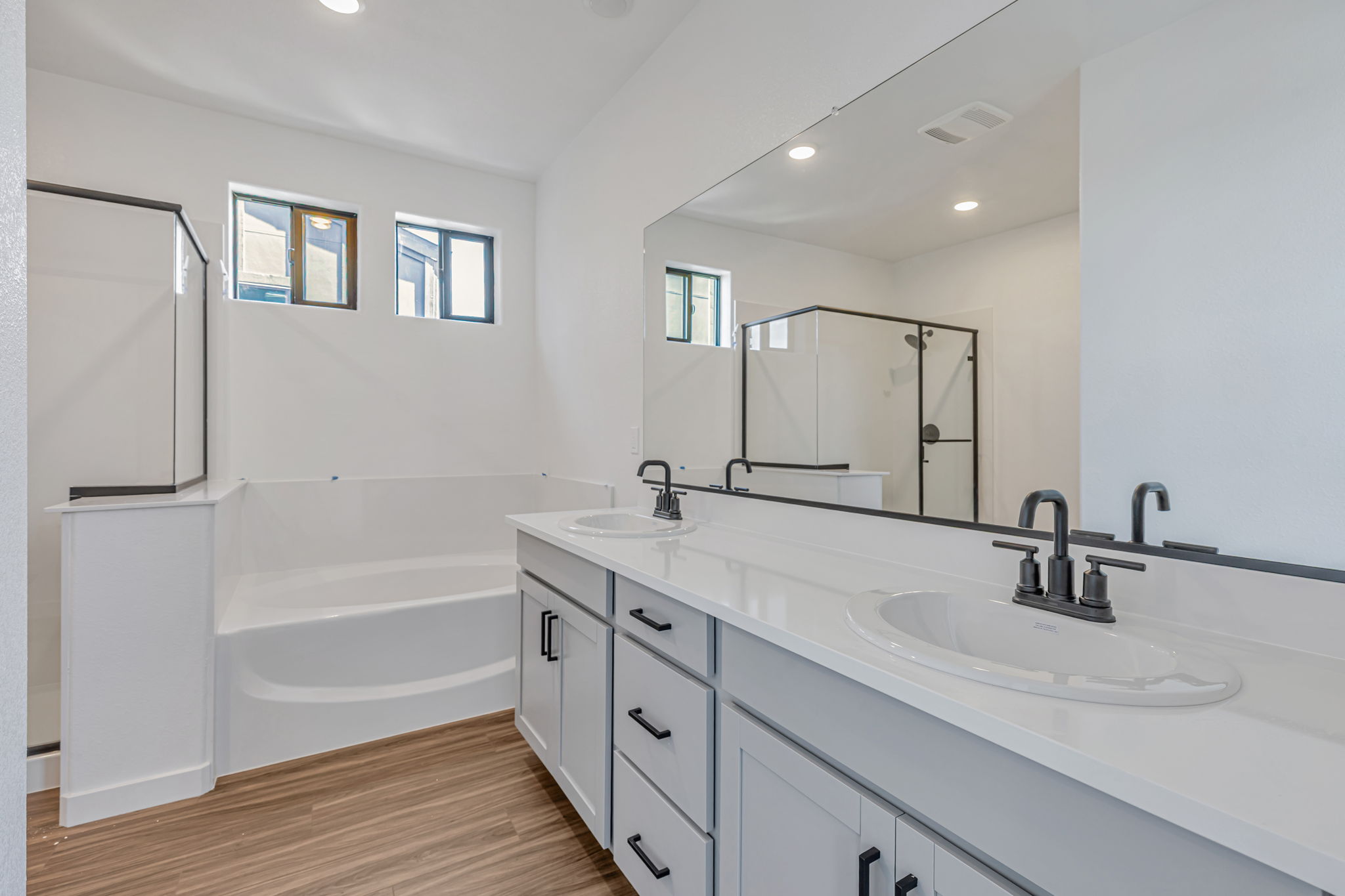 A bathroom with a tub sink and mirror.